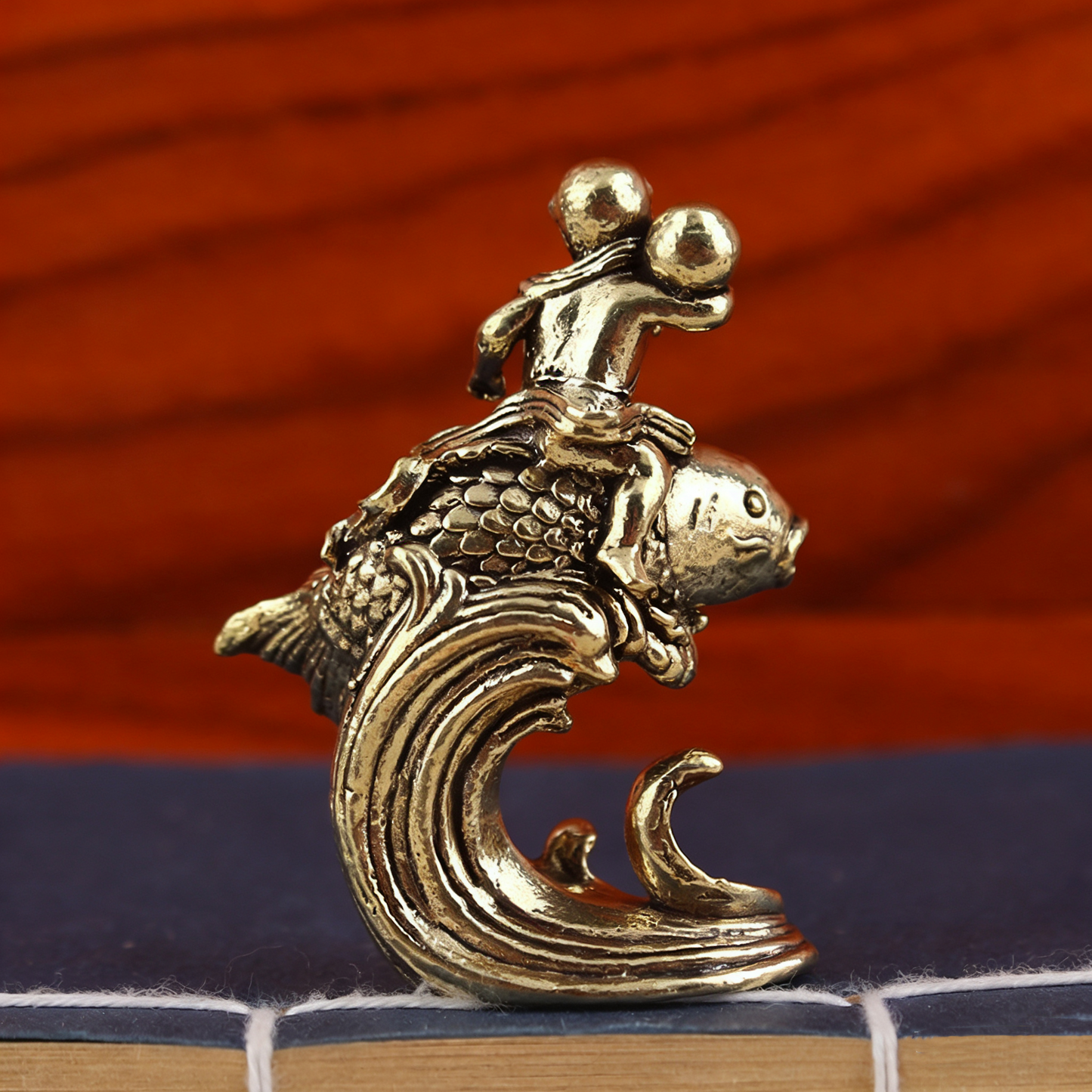 Brass child sitting on koi fish