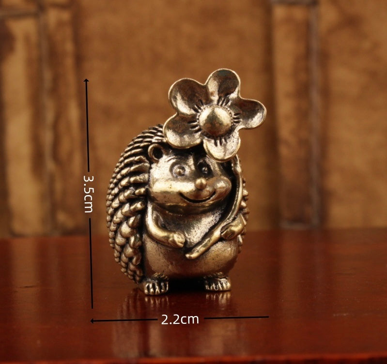 Brass hedgehog holding flower