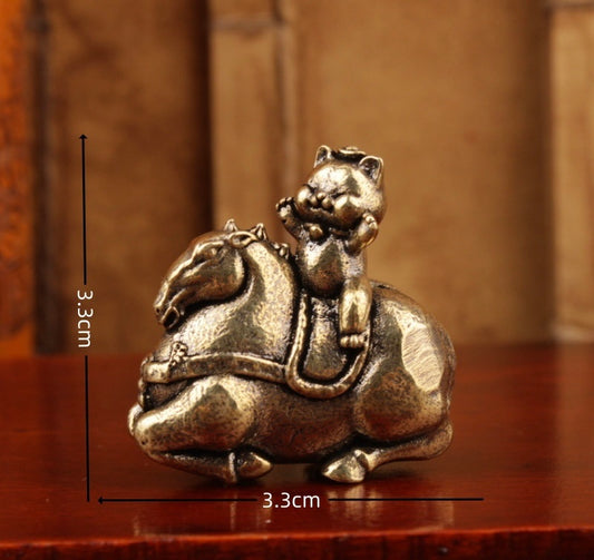 Brass kitty riding on horse