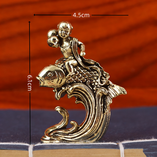 Brass child sitting on koi fish